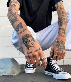 a man with tattoos on his arms and fingers