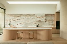 a kitchen with marble counter tops and stools