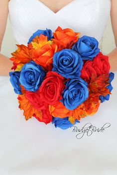 a bride holding a wedding bouquet with red, orange and blue flowers in it's center