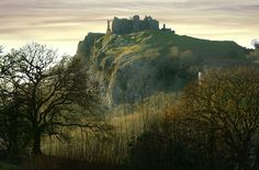 a castle on top of a hill surrounded by trees