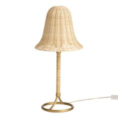 the lamp is made out of wicker and has a white cord attached to it