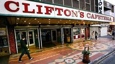 a man walking down the street in front of a building that says clifton's cafeteria