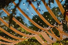 an outdoor wedding venue with white draping and string lights