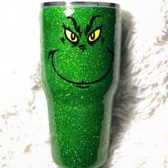 the grin face on this green glitter tumbler has yellow eyes