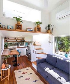 a living room filled with furniture next to a kitchen and dining area in a home