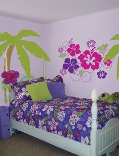 a bed room with a neatly made bed and flowers painted on the wall behind it