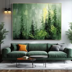 a living room with a green couch and large painting on the wall above it's coffee table