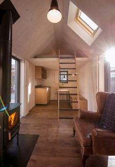 a living room filled with furniture and a fire place next to a loft type building