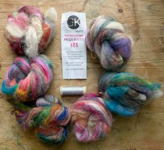 several skeins of multicolored wool sitting on top of a wooden table