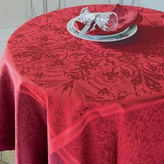 a red table cloth with a silver plate on it