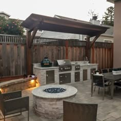 an outdoor kitchen and dining area is lit up