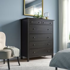 a bedroom scene with focus on the chest of drawers and a chair in the foreground