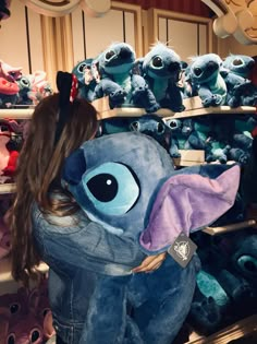 a girl is looking at stuffed animals in a toy store with her back to the camera