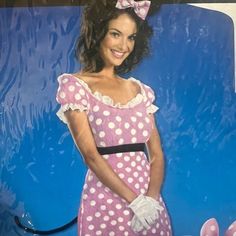 a woman in pink and white polka dot dress posing with her hands on her hips