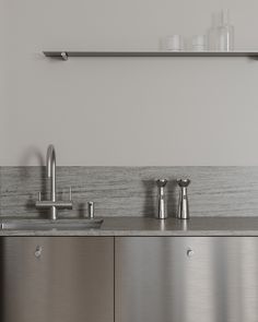 a stainless steel kitchen sink with two faucets