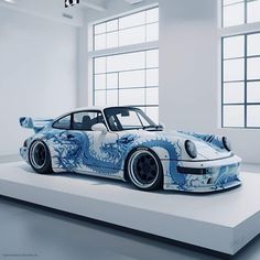 a blue and white car on display in an empty room