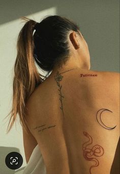 a woman with her back turned to the camera, has tattoos on her upper half