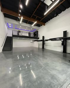 an empty room with stairs and lights on the ceiling