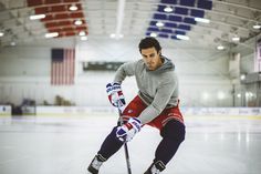 a man in grey shirt and red shorts playing ice hockey