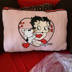 a pink pillow with a cartoon character hugging a white teddy bear on it's back