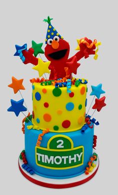 a birthday cake with the number two on top and stars around it is decorated in bright colors