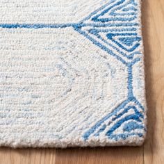 a blue and white area rug on a wooden floor with a wood floor in the background