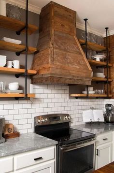 a stove top oven sitting inside of a kitchen next to wooden shelves filled with dishes