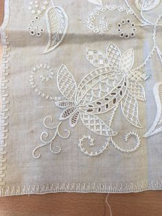 a piece of cloth with white embroidery on it