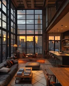 a living room filled with lots of furniture and tall buildings in the background at sunset