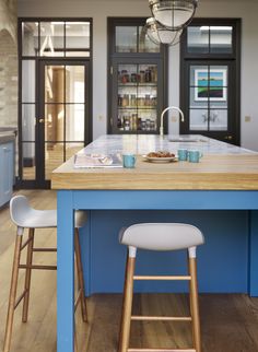 a kitchen island with two stools in front of it