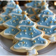 decorated cookies with blue and white icing are arranged on a plate in the shape of christmas trees