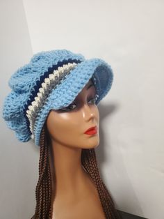 a mannequin head wearing a blue crochet hat with braids on it