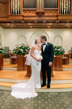 a bride and groom kiss in front of the organes at their wedding ceremony,