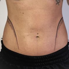 a woman's lower body with tattoos on her stomach and the bottom part of her belly