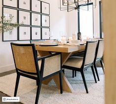 a dining room table with chairs and pictures on the wall behind it in front of a chandelier