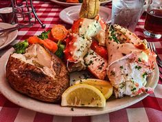 a white plate topped with lots of food on top of a checkered table cloth