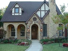 a brick house with arched windows and a walkway leading to the front door