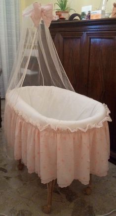 a baby crib with a pink ruffled bed skirt on it's bottom