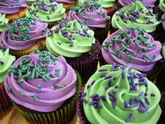 there are many cupcakes with green and purple frosting