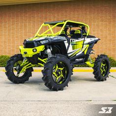 a yellow and black polaris atv parked in front of a building