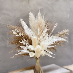 a vase filled with dried flowers on top of a table