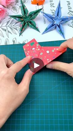 someone is cutting out origami stars with scissors