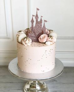 there is a cake that has pink frosting on it with a castle in the background