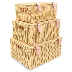 three wicker baskets stacked on top of each other with pink leather tags hanging from the handles