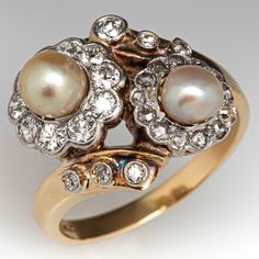 This elegant vintage ring is centered with two (2) platinum topped 14K yellow gold halo settings. One setting is centered with a natural pearl and bordered with ten (10), bead set, old European cut diamonds. The second setting is centered with a natural pearl and bordered with thirteen (13), bead set, rose cut diamonds. The by-pass style shank is accented with six (6), bezel set, round single cut/old European cut diamonds. The ring measures 15.0mm at the top, rises 6.6mm above the finger, taperi Vintage Pearl Rings Antiques, Luxury Intricate Design Pearl Ring For Anniversary, Luxury Yellow Gold Pearl Ring With Diamond, Luxury Multi-stone Heirloom Pearl Ring, Luxury Classic Pearl Ring With Rose Cut Diamonds, Luxury Elegant Pearl Ring With Bezel Setting, Luxury Hallmarked Yellow Gold Pearl Ring, Luxury Gold Pearl Ring With Diamonds, Luxury Pearl Engagement Ring With Gemstone