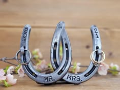 two metal horseshoes with the words mr and mrs on them sitting next to flowers