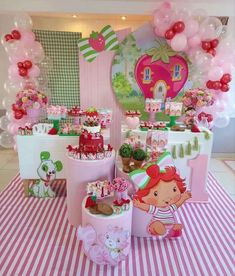 a table with pink and green decorations on it, including balloons and other items in the shape of animals