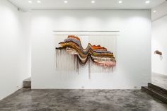 an abstract painting on display in a white room