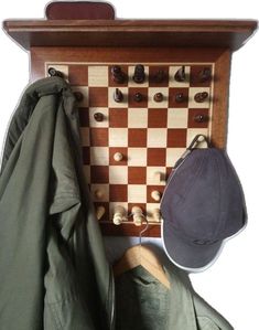 a hat and coat hang on a chess board