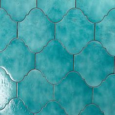 a close up view of a blue tile wall with an intricate design on the side